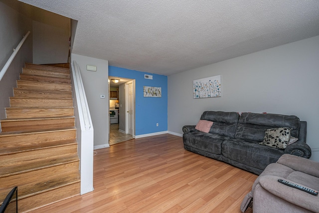 living room with wood-type flooring and a textured ceiling