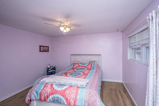 bedroom featuring ceiling fan, wood-type flooring, and a textured ceiling