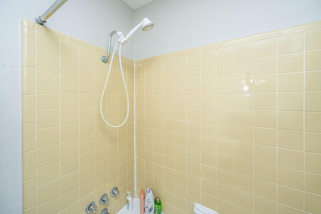 interior details featuring tiled shower / bath combo