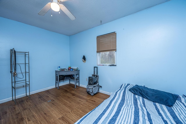 bedroom featuring hardwood / wood-style flooring, ceiling fan, and a textured ceiling