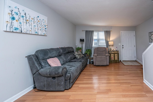 living room featuring light hardwood / wood-style floors and a textured ceiling