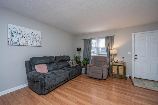 living room featuring a textured ceiling and light wood-type flooring