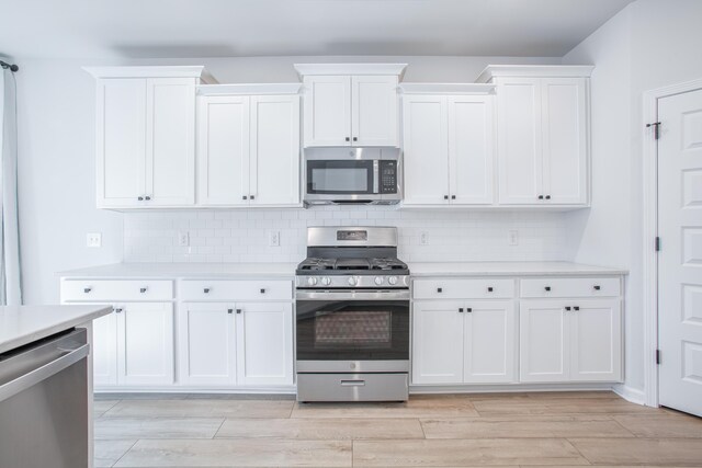 kitchen with white cabinetry, light hardwood / wood-style flooring, and stainless steel appliances