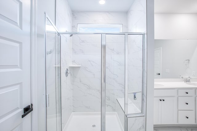 bathroom featuring a shower with door and vanity