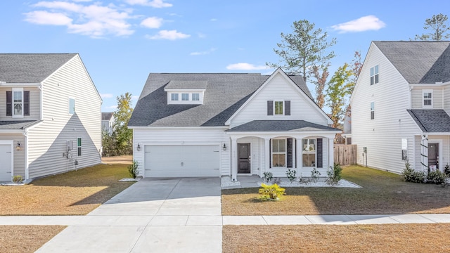 view of front of property with a garage, covered porch, and a front lawn