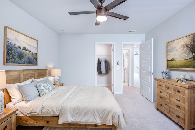 carpeted bedroom featuring a spacious closet, a closet, and ceiling fan