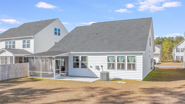 rear view of house with a sunroom, a yard, a patio, and central air condition unit