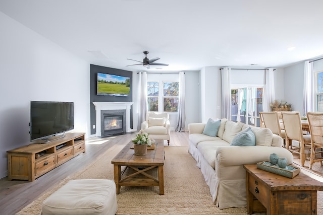 living room with light hardwood / wood-style floors and ceiling fan