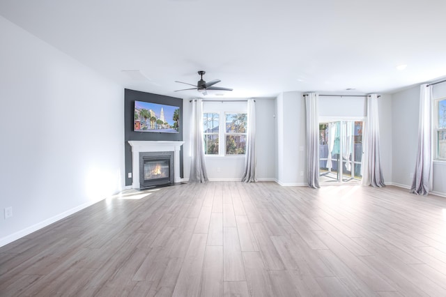 unfurnished living room featuring ceiling fan and light hardwood / wood-style flooring