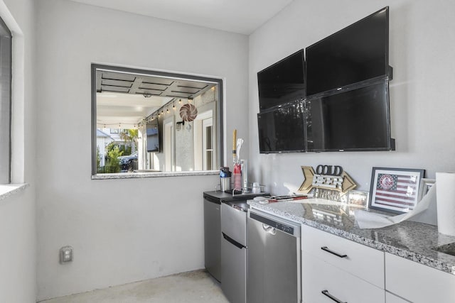 kitchen featuring dishwasher, stone counters, white cabinetry, and concrete flooring