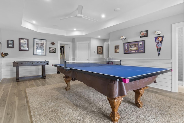 playroom featuring a wainscoted wall, ceiling fan, a tray ceiling, light wood-style floors, and recessed lighting