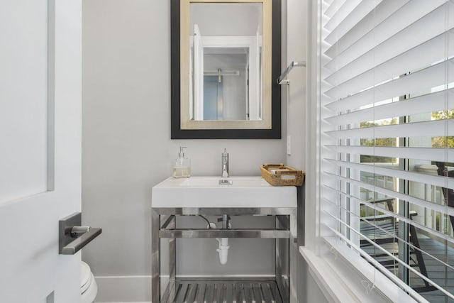 bathroom featuring a sink, toilet, and baseboards