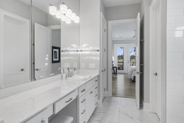 bathroom with marble finish floor, connected bathroom, and vanity