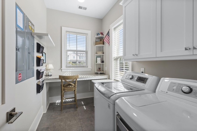 laundry area featuring cabinet space, visible vents, washer and clothes dryer, and dark tile patterned flooring