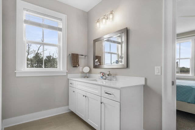 bathroom with tile patterned floors, ensuite bath, vanity, and baseboards