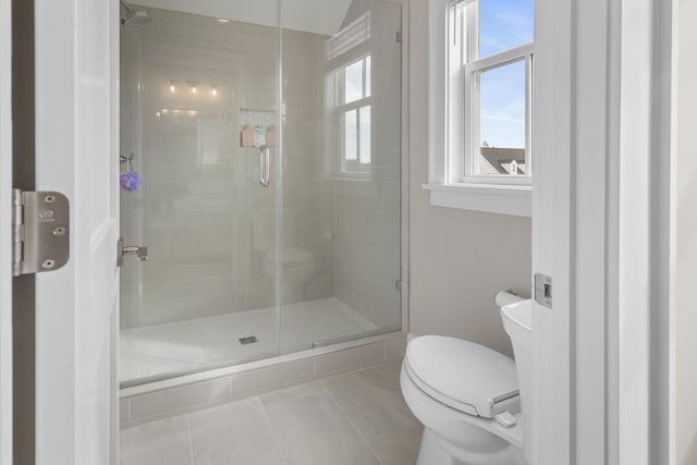 bathroom with toilet, a shower stall, and tile patterned flooring