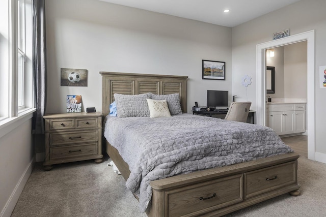 bedroom featuring light carpet, recessed lighting, ensuite bathroom, and baseboards