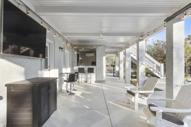 view of patio featuring ceiling fan and stairway