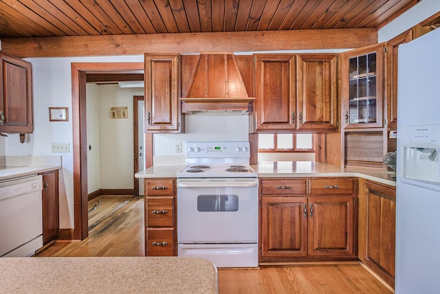 kitchen with light countertops, light wood finished floors, extractor fan, and white appliances