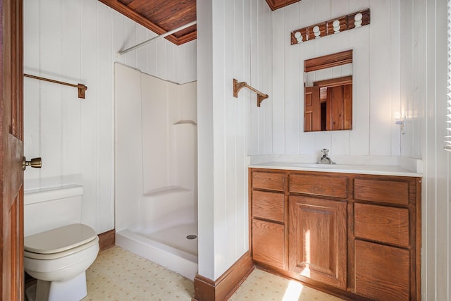 full bathroom featuring a stall shower, vanity, tile patterned floors, toilet, and wooden walls