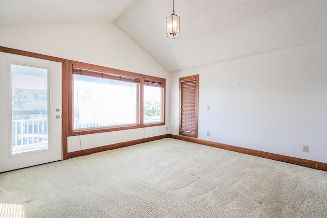 carpeted spare room with a healthy amount of sunlight, baseboards, and lofted ceiling