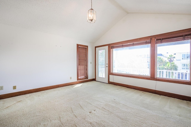 spare room with light colored carpet, baseboards, and high vaulted ceiling