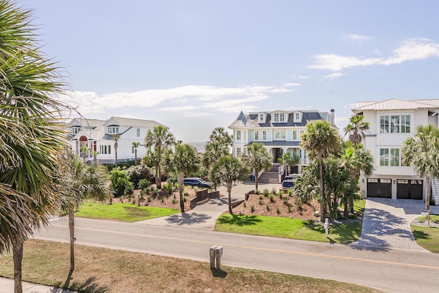 surrounding community featuring a garage, decorative driveway, and a residential view