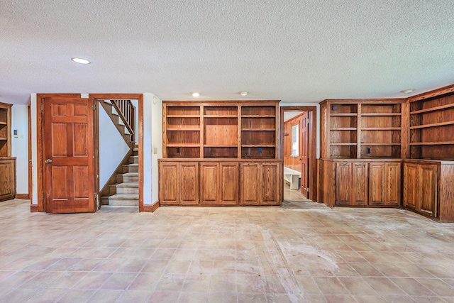unfurnished living room featuring stairs, recessed lighting, a textured ceiling, and built in features