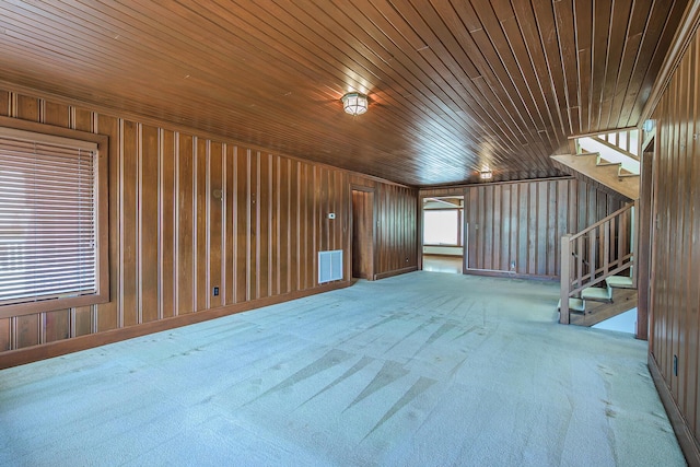 interior space with visible vents, wooden walls, stairway, wood ceiling, and carpet flooring