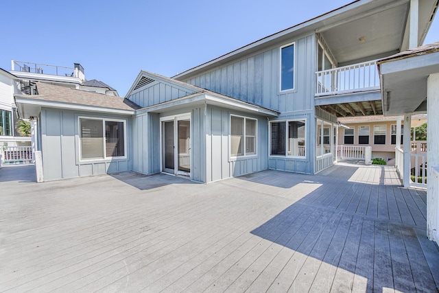 rear view of house with board and batten siding and a balcony