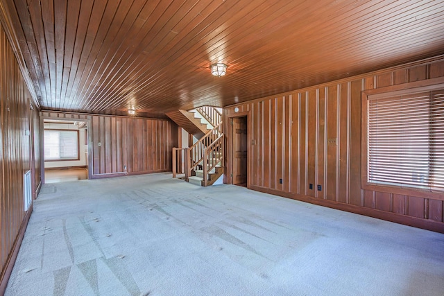 bonus room featuring stairs, wood walls, wood ceiling, and carpet