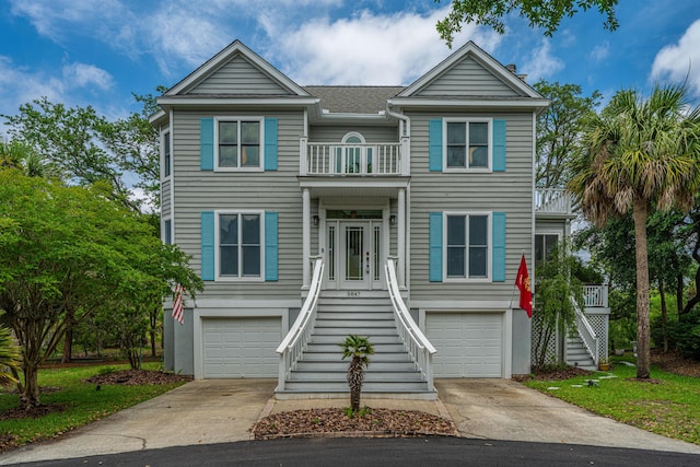 5847 Back Bay Dr, Isle Of Palms, SC 29451 - raised beach house featuring stairs, a balcony, concrete driveway, and an attached garage