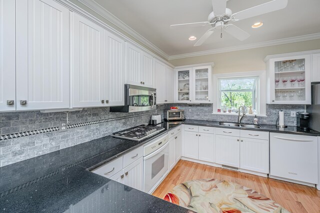 5847 Back Bay Dr, Isle Of Palms, SC 29451 - kitchen with a sink, stainless steel appliances, backsplash, ornamental molding, and light wood-type flooring