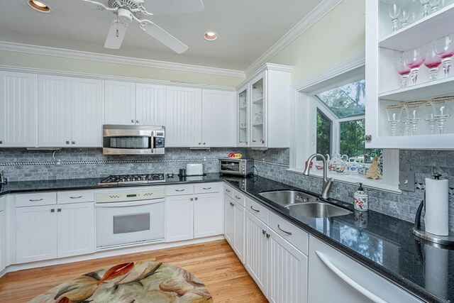 5847 Back Bay Dr, Isle Of Palms, SC 29451 - kitchen with appliances with stainless steel finishes, a sink, ornamental molding, dark stone countertops, and white cabinetry