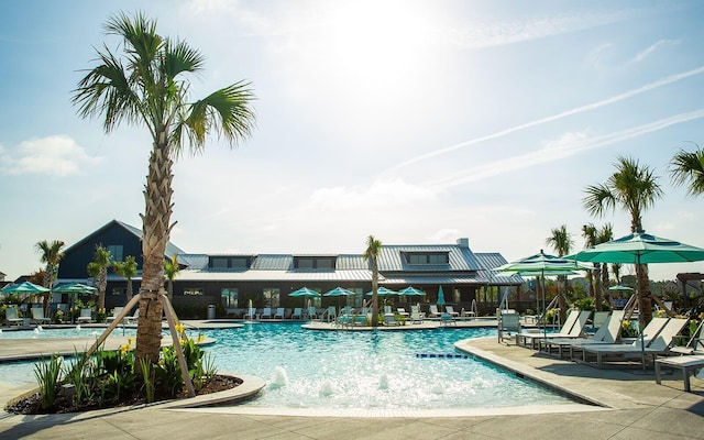 view of swimming pool featuring pool water feature and a patio