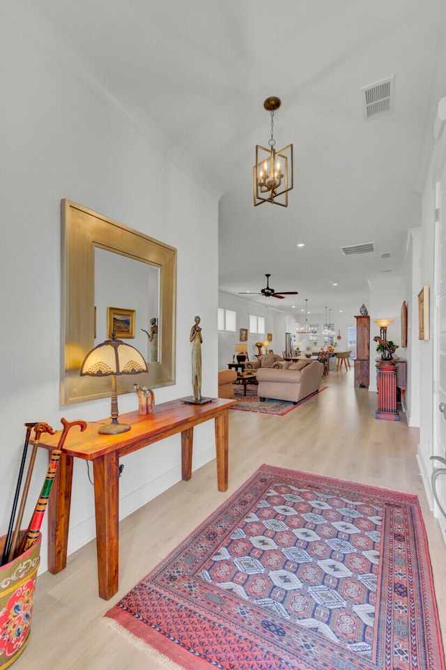 hallway featuring a notable chandelier and light wood-type flooring