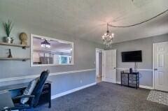 unfurnished office featuring a chandelier and dark colored carpet