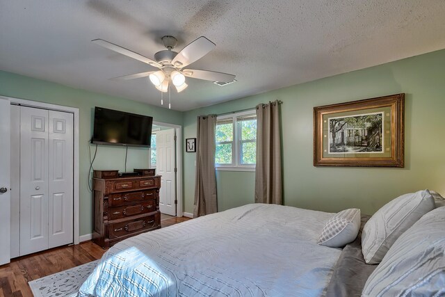 bedroom with dark hardwood / wood-style flooring, a closet, a textured ceiling, and ceiling fan