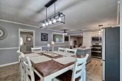 dining area with hardwood / wood-style flooring and crown molding