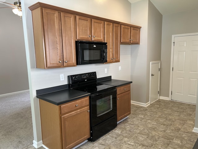 kitchen with black appliances, dark countertops, brown cabinets, a ceiling fan, and baseboards