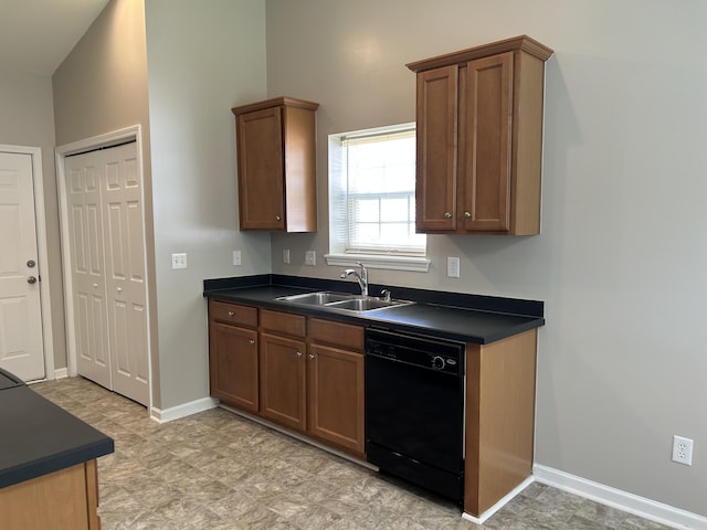 kitchen with dishwasher, a sink, dark countertops, and baseboards