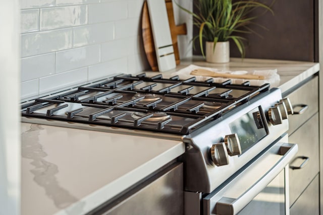 detailed view of stainless steel gas range and backsplash