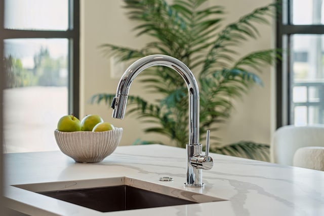 kitchen view of a sink and light stone countertops