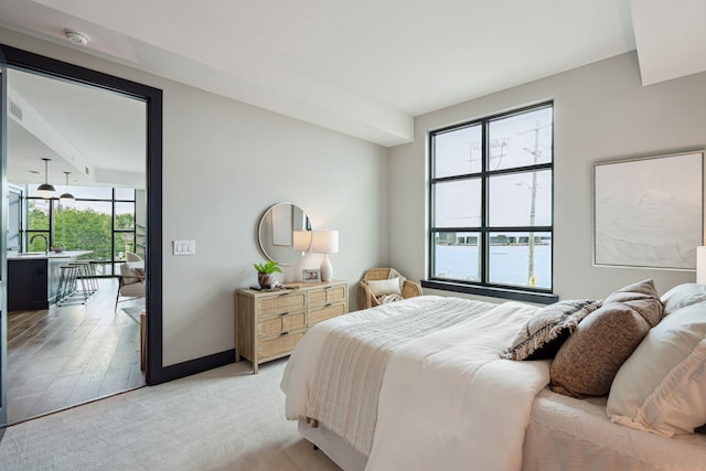 bedroom with baseboards and light colored carpet