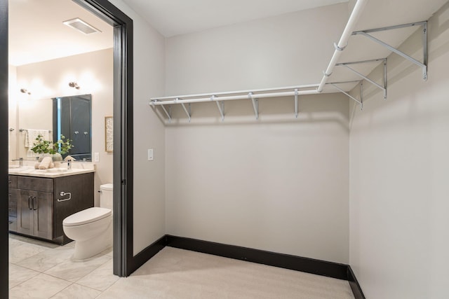 walk in closet featuring a sink
