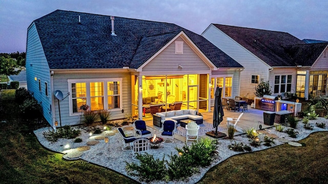 rear view of property with a patio area, an outdoor living space with a fire pit, and an outdoor kitchen