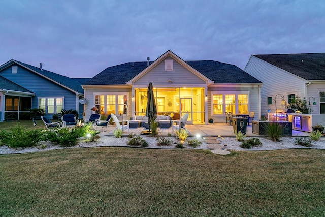 rear view of property featuring an outdoor living space, a yard, and a patio area