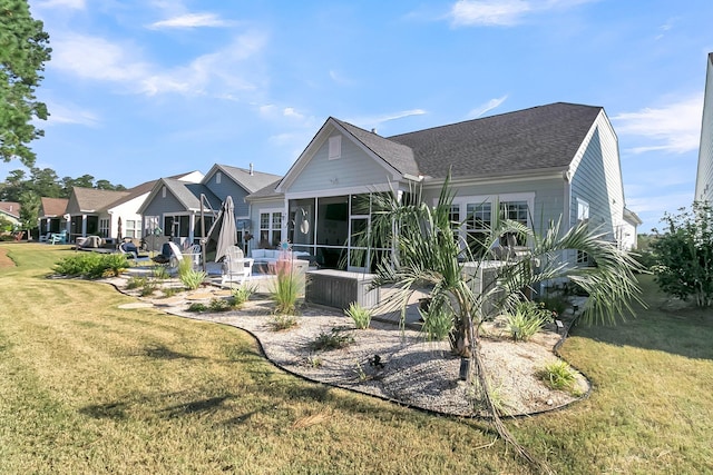 back of property featuring a patio area, a sunroom, and a lawn