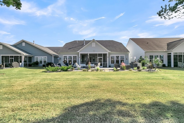 back of property with a yard and a sunroom