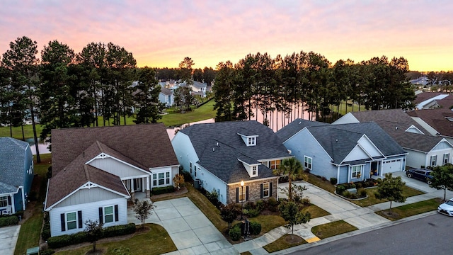 aerial view at dusk featuring a water view